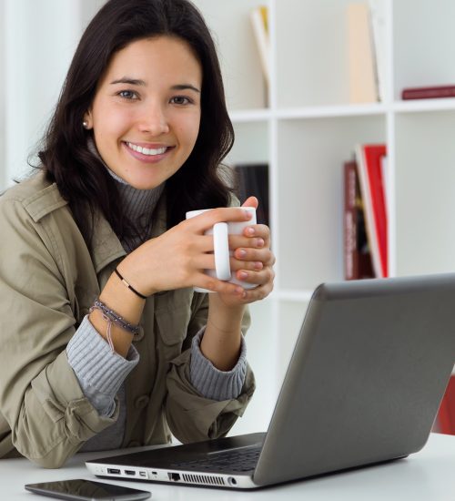 Beautiful young woman using her laptop at home.